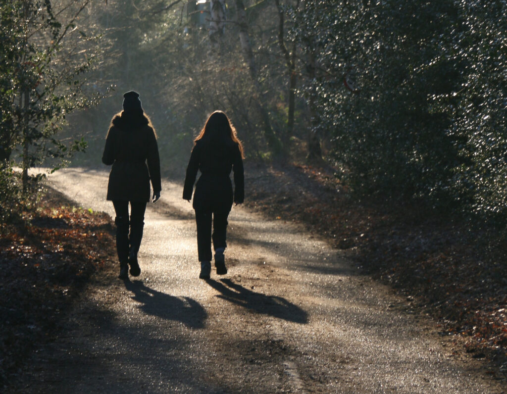 Two females embracing winter by going for a walk