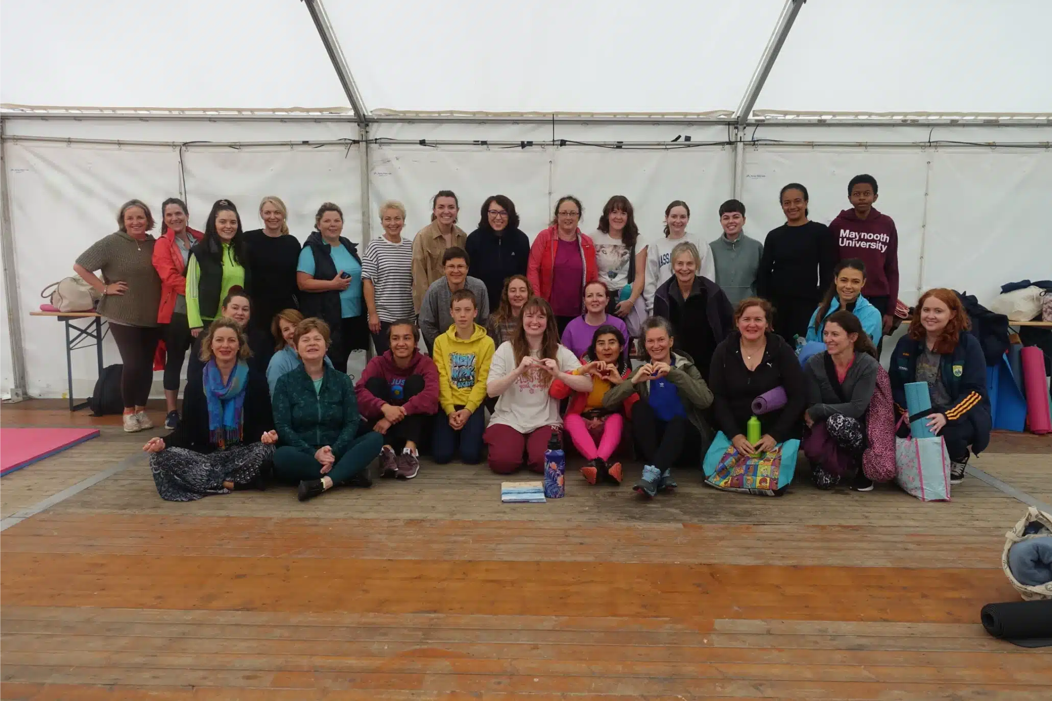 A large group of people gather after practising yoga together in the marquee during a Quest and Thrive wellness session at Tralee Street Festival.
